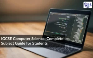 Students studying IGCSE Computer Science with code displayed on a laptop screen